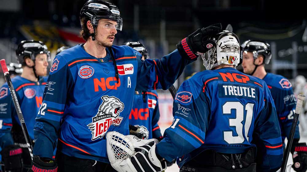 Eishockeyspieler in blauen Trikots während eines Spiels auf dem Eis.