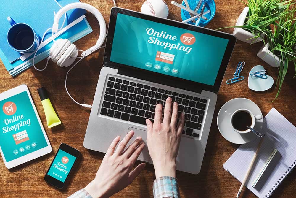 Laptop mit Online Shopping Website, Smartphone, Tablet und Zubehör.