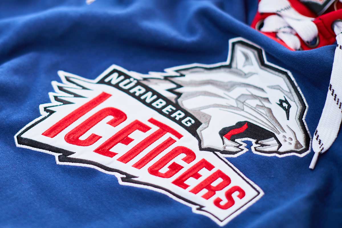 Nürnberg Ice Tigers Logo auf blauer Eishockeyjacke.