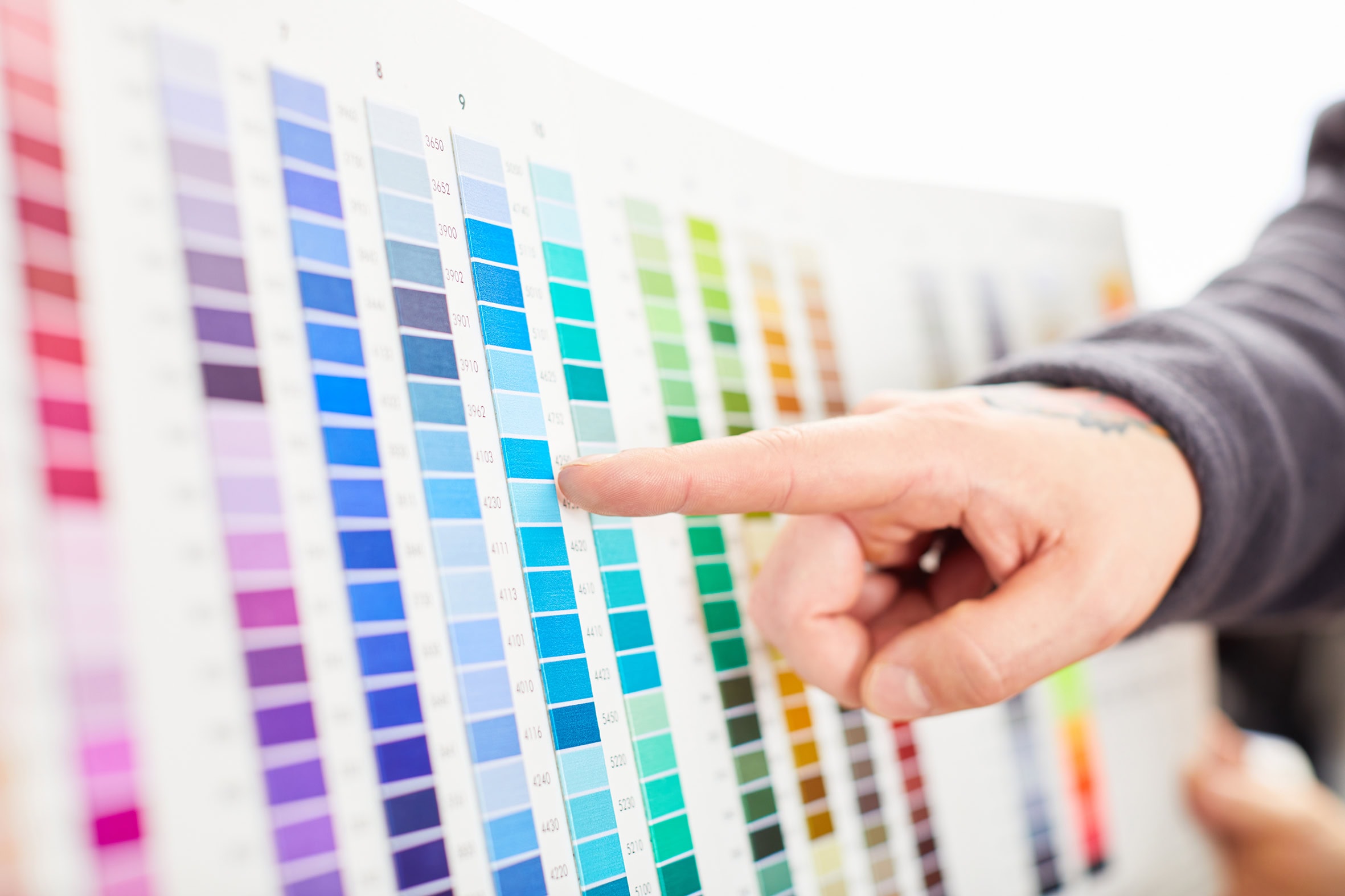 Person wählt Farbe aus einer Farbpalette für Beratung.